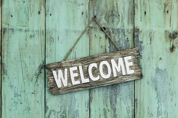 Wall Mural - Welcome sign hanging on mint green wood door