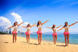 © SlavaStock - cheerleaders in dance pose bent arms on beach against sea