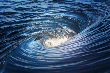 the raging whirlpool on surface of the deep river