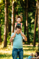 Wall Mural - Young father with daughter having fun outdoors.