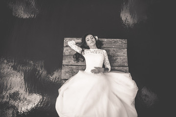 stylish gorgeous happy brunette bride on the pier on the backgro