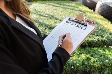 Wall Mural - Businesswoman signing a car insurance policy on the street