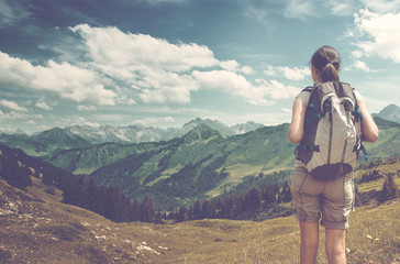 Wall Mural - female hiker admiring view of mountain valley