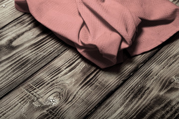 Red kitchen towel on old wooden burned table or board for backgr