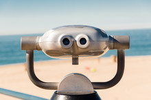 Coin Operated Binoculars On A Pier Overlooking The Beach