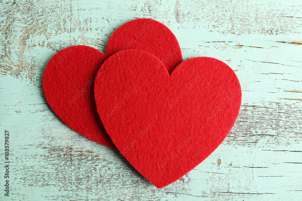 Red felt hearts on blue wooden background