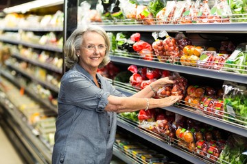 Wall Mural - Senior woman picking out some vegetables