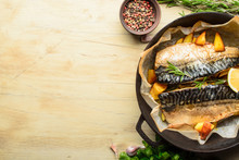 Baked Fish Mackerel With Baked Potato In A Pan, Rosemary, Lemon And Spice On A Wooden Background