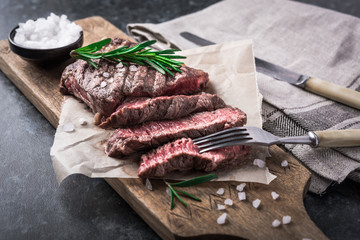 Wall Mural - Grilled beef steak with rosemary and salt on cutting board