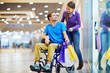 © pressmaster - Caring girl talking to her boyfriend in wheelchair during sale