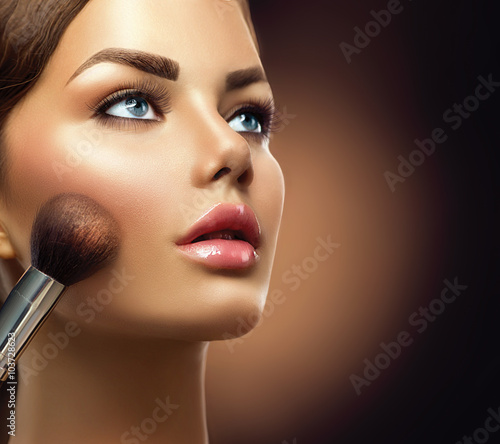 Naklejka na drzwi Makeup. Beauty model girl applying make-up closeup
