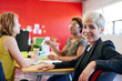 © AYAimages - Confident female designer sitting at her desk for a brainstorming in red creative office space