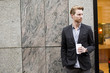 © BGStock72 - Young man drinking coffee to go on street