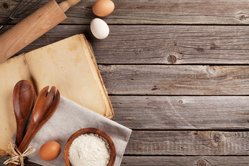 Kitchen table with cookbook, utensils and ingredients