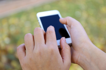 Woman holding smartphone outside