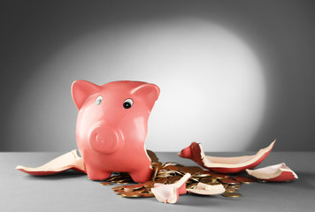 Canvas Print - Broken piggy bank on the table against grey background, close up