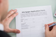 © Andrey Popov - Person Hand Over Mortgage Application Form
