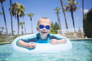 Cute little boy having fun in the swimming pool while on vacation 