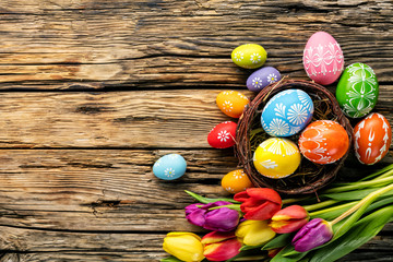 Easter eggs and tulips on wooden planks