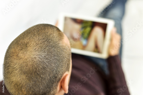 Photographie  young man watching porn in his tablet
