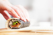 © Photocreo Bednarek - Preparing, rolling sushi. Salmon, avocado, rice and chopsticks on wooden table.