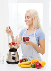 Wall Mural - smiling woman with blender preparing shake at home