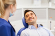 © Syda Productions - female dentist with happy male patient at clinic