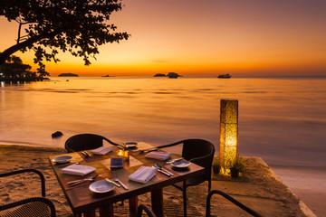 Romantic sunset on the shore of a tropical island. Cafe on the b