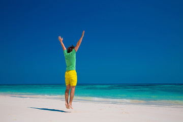 Freedom Beach Summer Holiday Concept. Handsome young man jumping