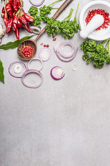 Various flavoring with wooden cooking spoon,  mortar and pestle  on gray concrete texture background, top view, place for text.