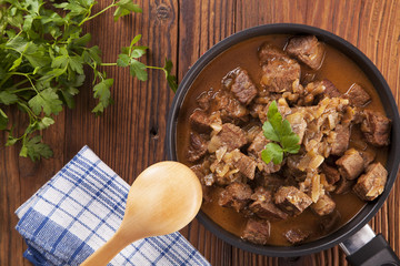 Beef stew - wooden background