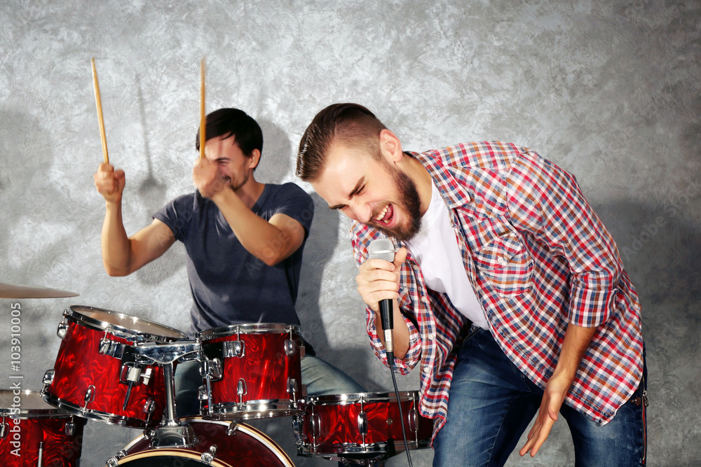 Musicians playing musical instruments and singing songs in a studio