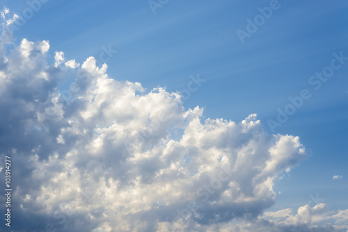 Obraz w ramie Sunbeam through the haze on blue sky: can be used as background and dramatic look, sun through the clouds