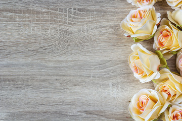 border of peach roses on a wooden background with empty space fo