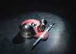 Armor helmet, sword and knight glove lie on a red shield on a gray background