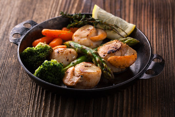 Wall Mural - Fried scallops in a sauce with asparagus and broccoli