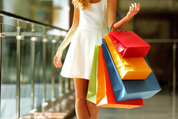 Wall Mural - Beautiful young woman with bags in shopping center