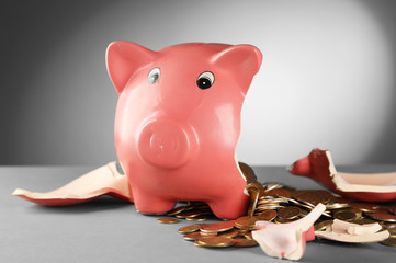 Canvas Print - Broken piggy bank on the table against grey background, close up