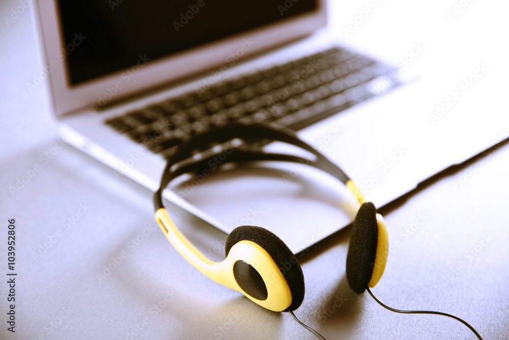 Headphones and laptop on table closeup