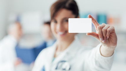 Wall Mural - Female doctor holding a business card