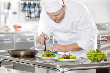 Wall Mural - Professional chef prepare steak dish at restaurant