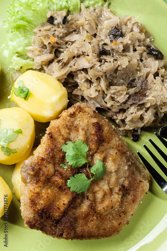 Nowoczesny obraz na płótnie Fried pork schnitzel served with boiled potatoes and fried sauer