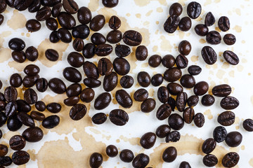 Wall Mural - Coffee beans and coffee stains on a white tablecloth..