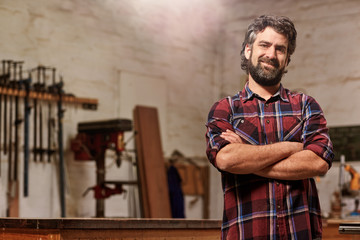 Wall Mural - Small carpentry business owner smiling with arms crossed