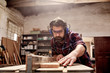 © mavoimages - Carpentry business owner cutting a plank of wood in workshop