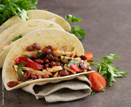 Fototapeta na wymiar Mexican food is tacos on wheat tortilla with chicken and beans