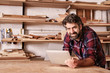 © mavoimages - Smiling small business owner in woodwork studio with digital tab