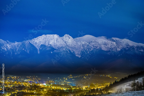 Plakat Panorama góry nocą światła miasta