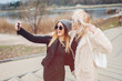 © sergiubirca - Outdoor lifestyle portrait of two best friends, smiling and having fun together, enjoy each other company posing and making selfie pictures to each other and share happiness