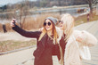 © sergiubirca - Outdoor lifestyle portrait of two best friends, smiling and having fun together, enjoy each other company posing and making selfie pictures to each other and share happiness